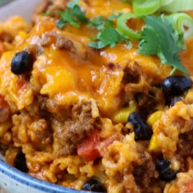 Savory beef enchilada casserole layered with rice and topped with cheese