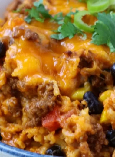 Savory beef enchilada casserole layered with rice and topped with cheese