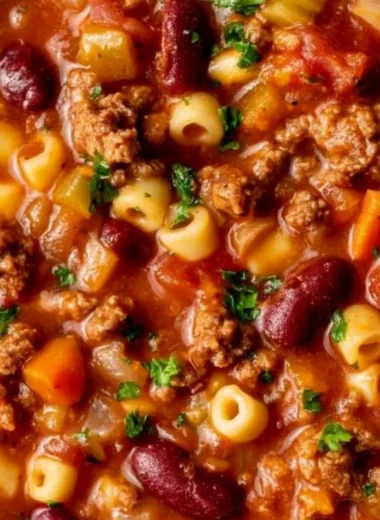 Cozy pasta and beans dish served in a bowl with herbs and spices.